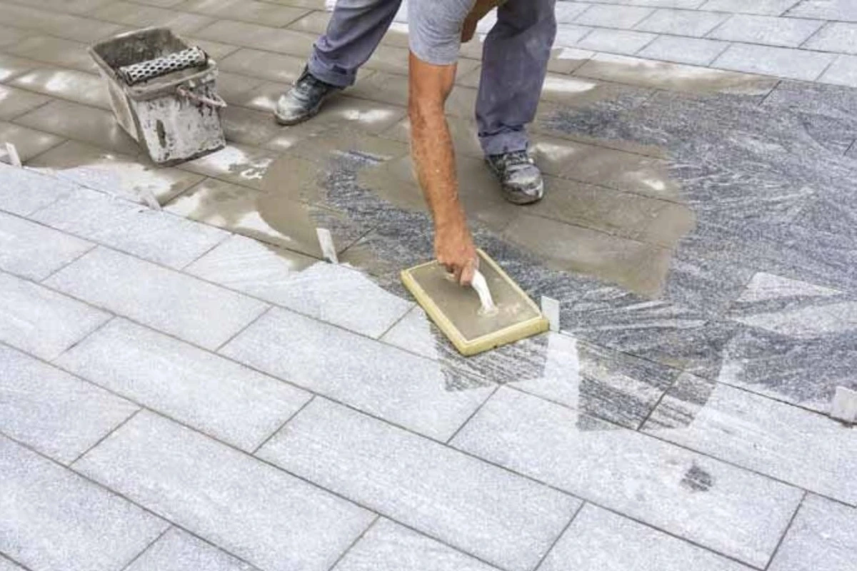 Delavec nanaša fugirno maso DECOLOR FM50 med ploščami iz naravnega kamna, primerna za zunanje površine in široke fuge.